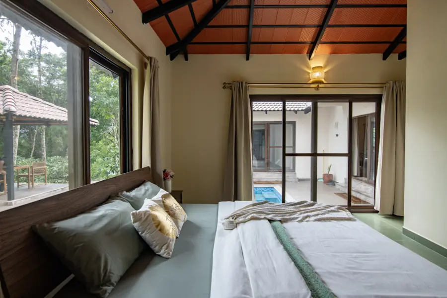 Bedroom with corner windows onto tall trees