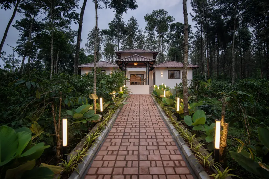 Lamp-lit brick path to the house at dusk