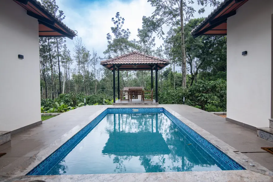 Pool leading to the tiled gazebo, framed by the two wings of the house